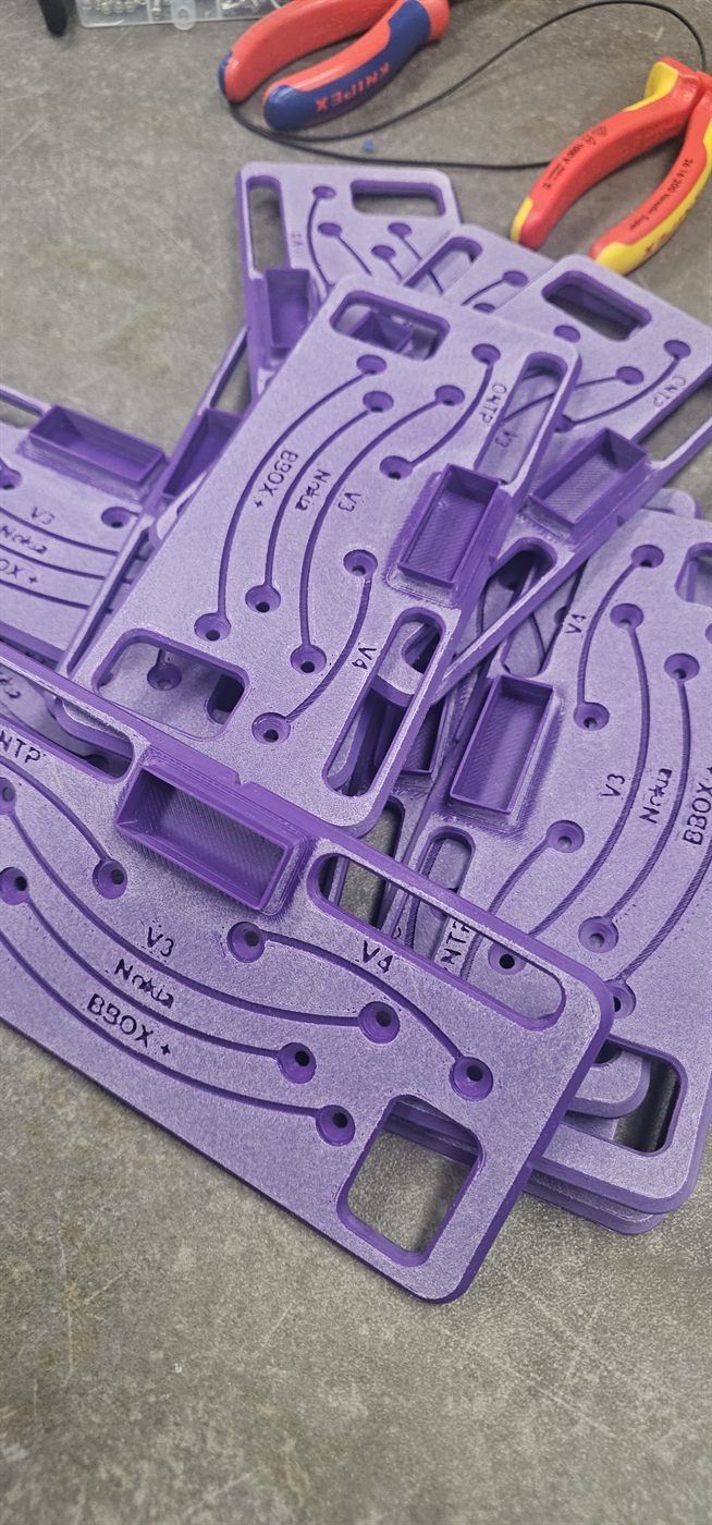 Stack of printed jigs, routing lines and labels engraved in the surface