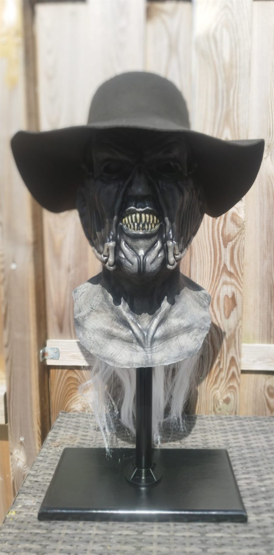 Creature bust with hat, printed and finished by hand, on a display stand